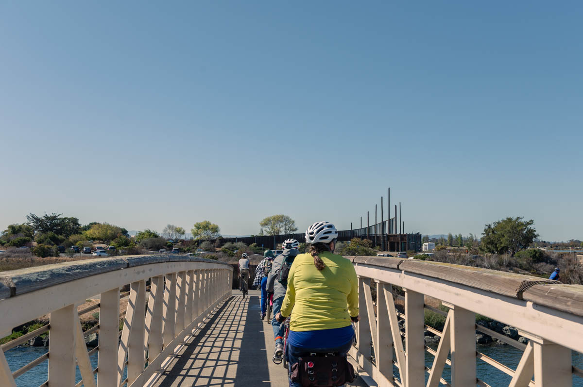 bicyclists on bridge over san leandro creek