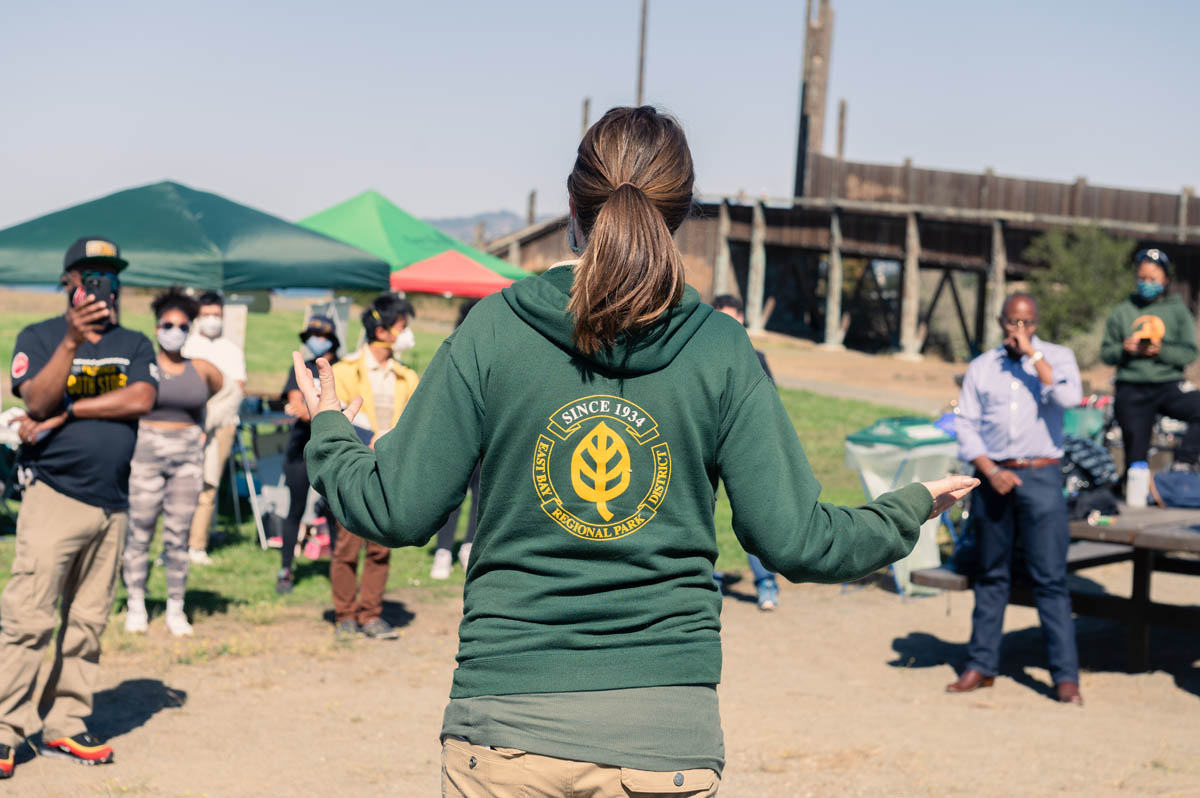 speaker in park uniform tells people about the park