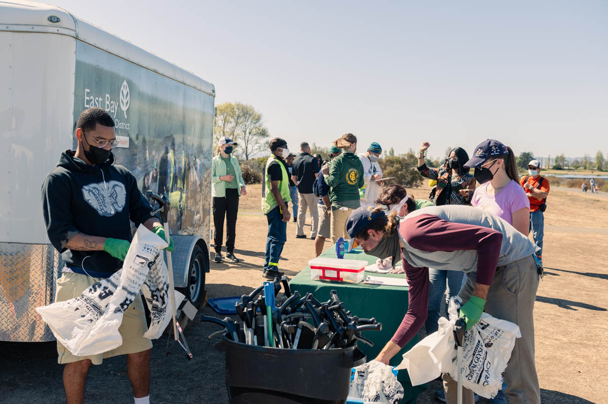 East Bay Parks van provides equipment for litter clean up at table to volunteers.