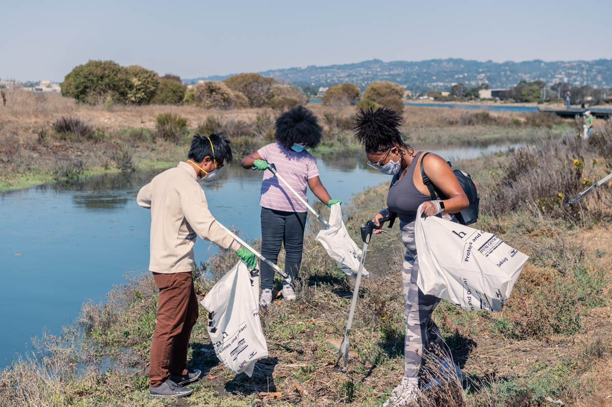 3 people picking up litter including young person