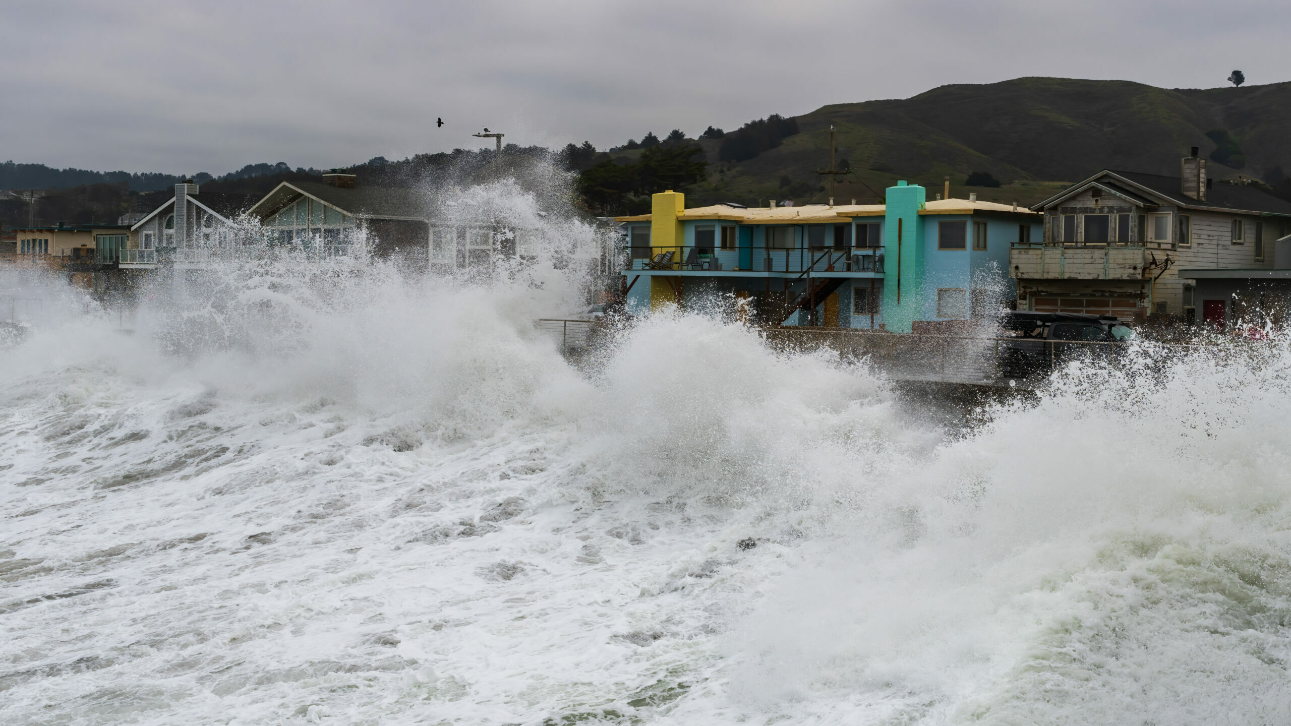 Waves breaking over houses in Pacifica, CA