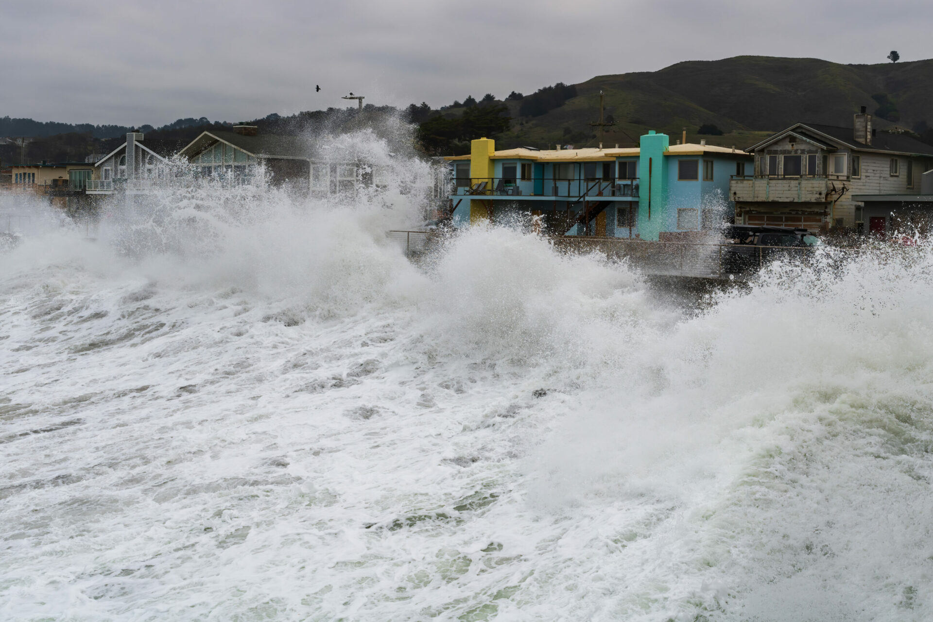 Las olas rompen sobre las casas de Pacifica durante la marea alta. La marea alta del día anterior fue una marea real (la más alta del año), pero las fuertes olas empujaron el océano más alto aún ese día. Foto: David Chamberlin.