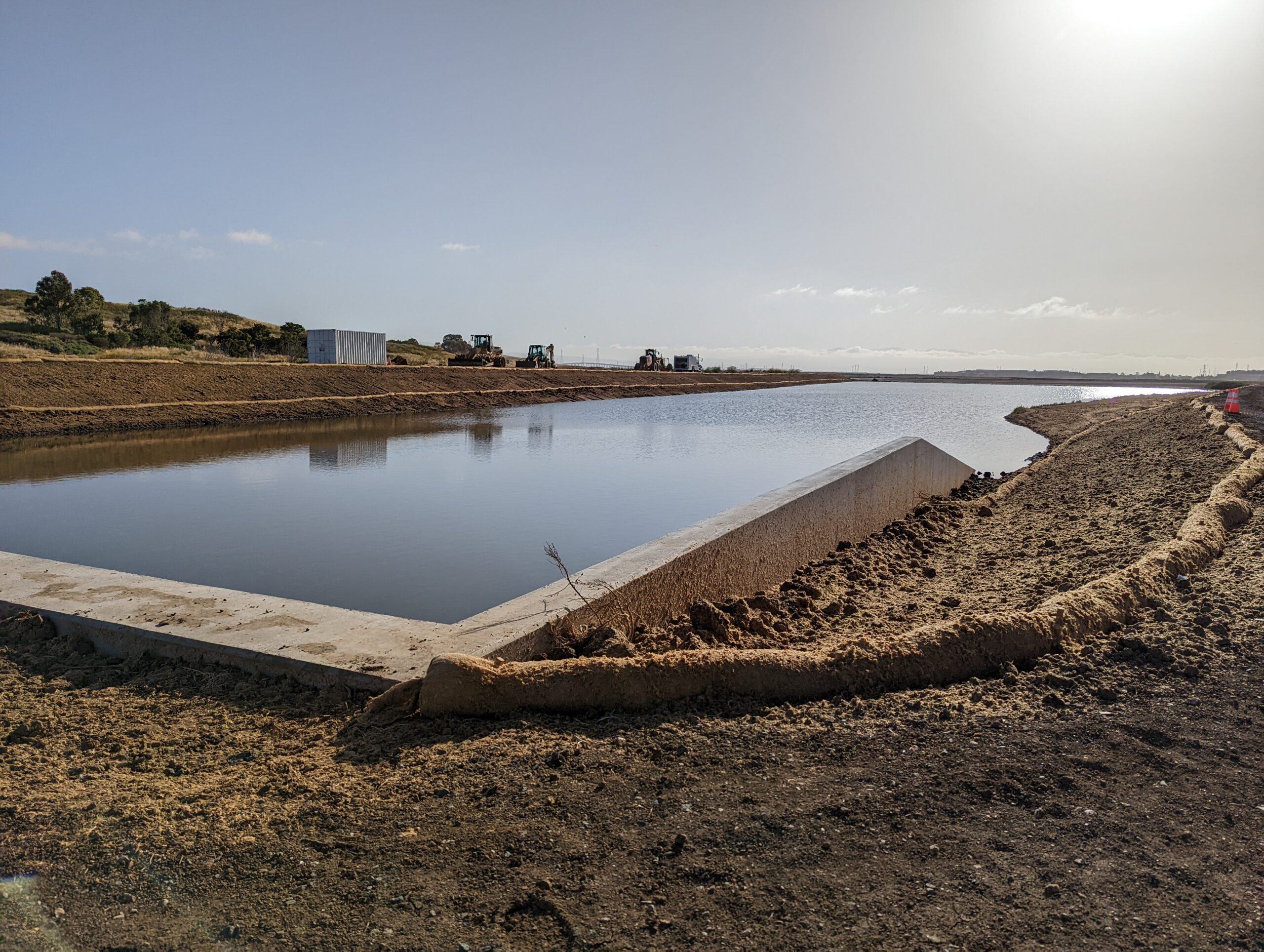 Waterway surrounded by freshly disturbed dirt.