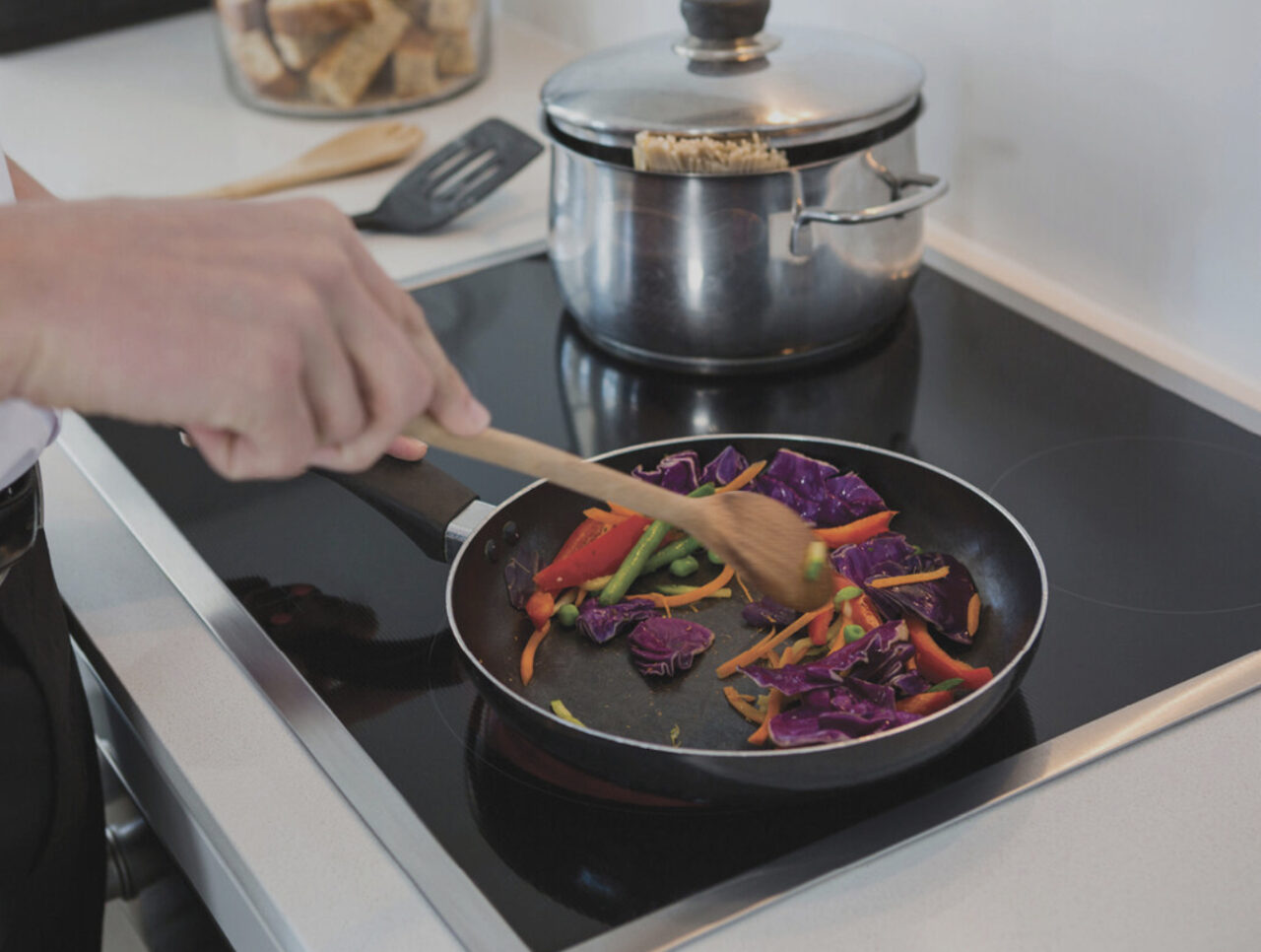 person cooking on electric stovetop